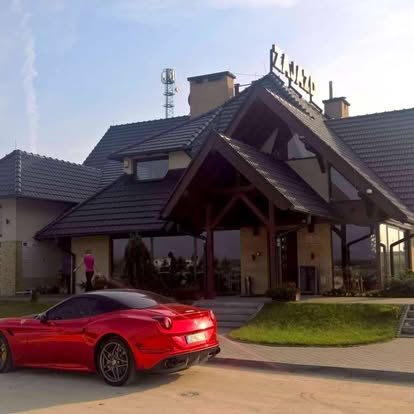 Czerwone Ferrari California przed zajazdem Wilczyniec
