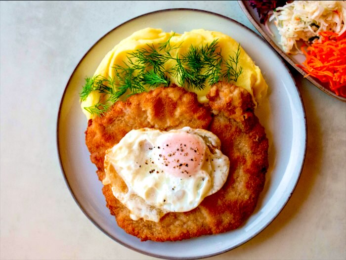 Kotlet schabowy z jajkiem sadzonym, puree z koperkiem i surówkami
