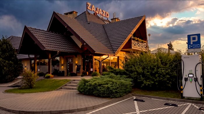 Zajazd Wilczyniec o zachodzie słońca z ładowarką samochodów elektrycznych